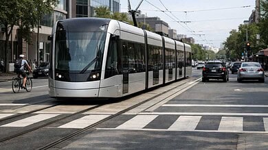 Modern light rail train operating in urban street corridor with overhead catenary wire