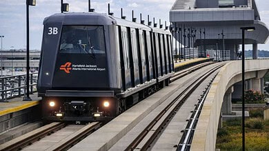 Automated people mover train at airport terminal station with platform screen doors
