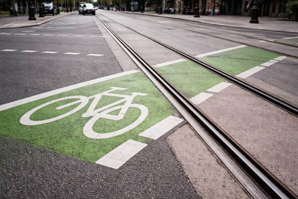 Urban intersection showing bicycle lane crossing light rail tracks at acute angle