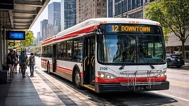 Modern public transit bus at urban bus stop with passengers boarding